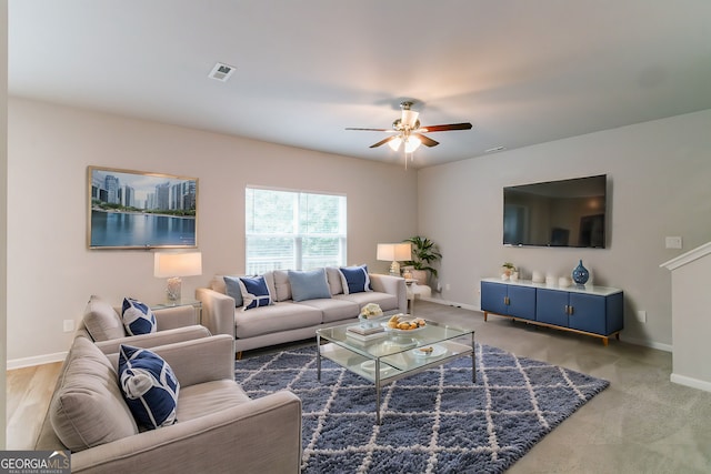 living room with ceiling fan and carpet