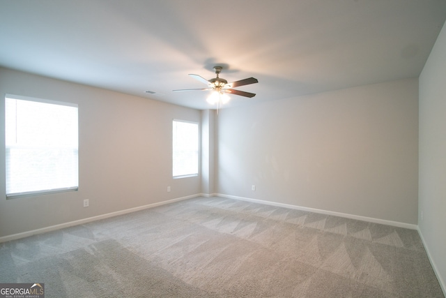 spare room featuring light carpet and ceiling fan