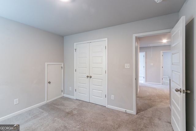 unfurnished bedroom with light carpet and a closet