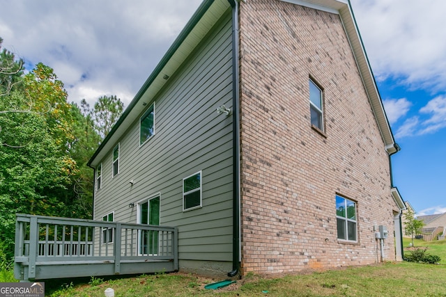 view of home's exterior featuring a lawn and a wooden deck