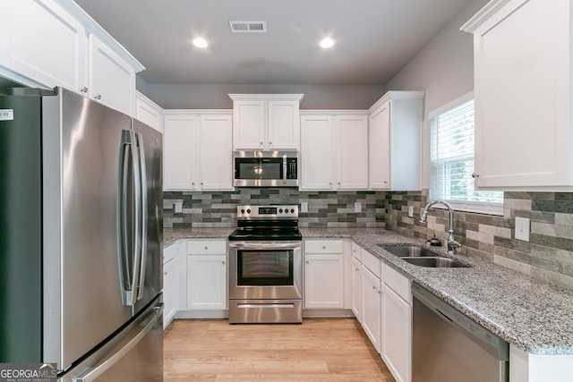 kitchen with white cabinetry, sink, and stainless steel appliances