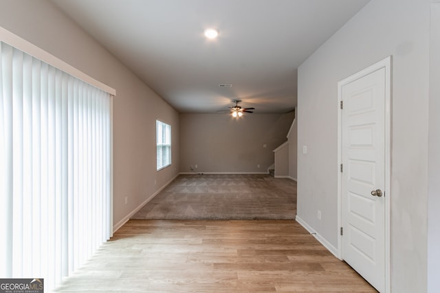 unfurnished living room with ceiling fan and light hardwood / wood-style flooring