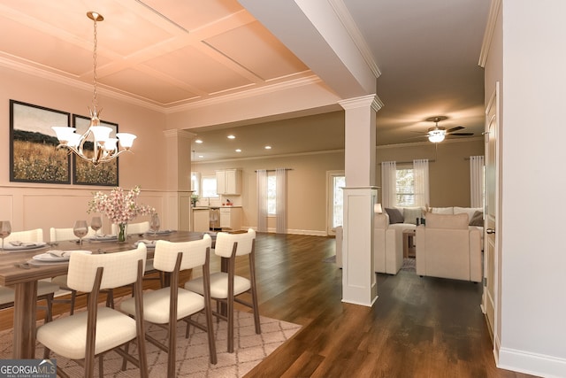 dining space with ceiling fan with notable chandelier, dark hardwood / wood-style floors, decorative columns, and crown molding