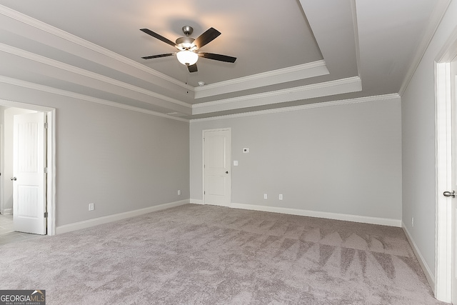 carpeted spare room featuring ceiling fan, a raised ceiling, and crown molding