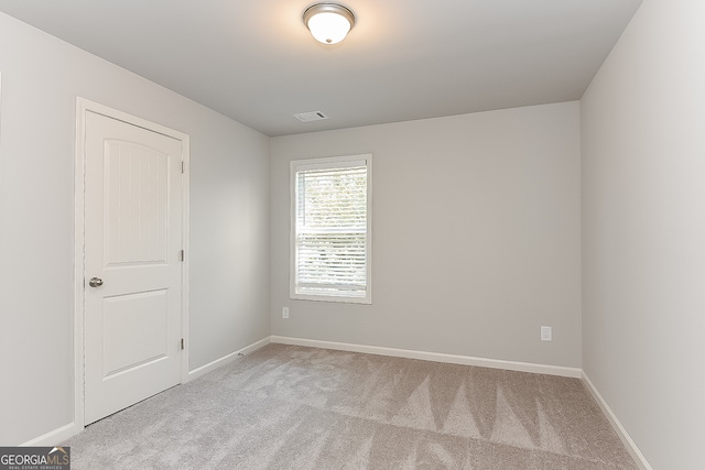 unfurnished room featuring light colored carpet