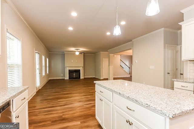 kitchen with pendant lighting, ornamental molding, white cabinetry, hardwood / wood-style flooring, and a center island