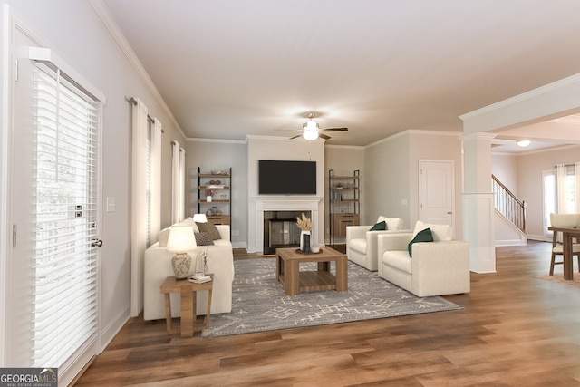 living room with ornate columns, ornamental molding, hardwood / wood-style floors, and ceiling fan