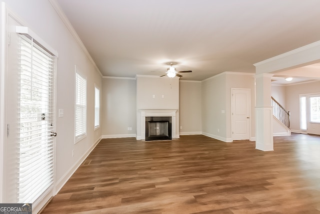 unfurnished living room with crown molding, ceiling fan, dark wood-type flooring, and ornate columns