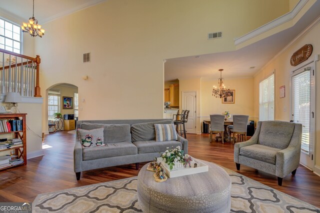 living room with ornamental molding, a towering ceiling, and dark hardwood / wood-style flooring