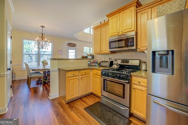 kitchen with light stone counters, appliances with stainless steel finishes, light wood-type flooring, and crown molding