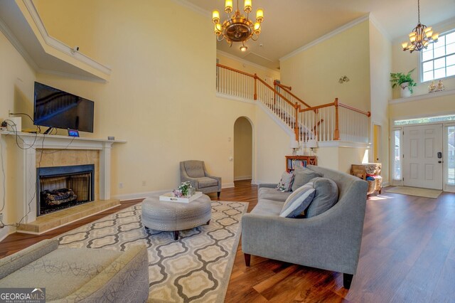 living room with wood-type flooring, a high ceiling, and crown molding