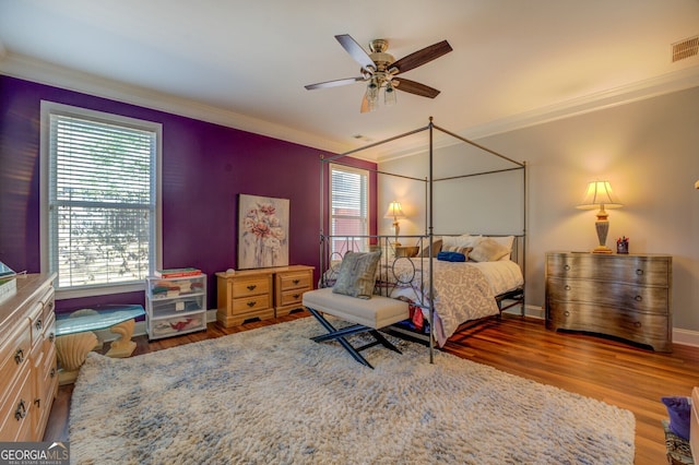 bedroom featuring ceiling fan, hardwood / wood-style flooring, and crown molding