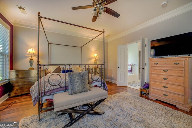 bedroom with ceiling fan, connected bathroom, crown molding, and wood-type flooring