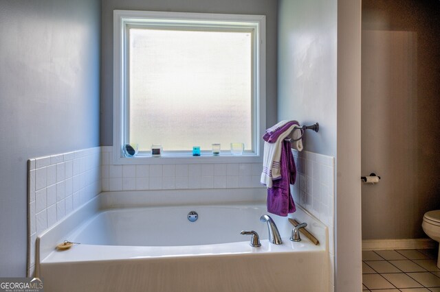 bathroom with a tub, toilet, and a wealth of natural light