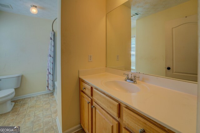 full bathroom with shower / bath combo, a textured ceiling, vanity, and toilet