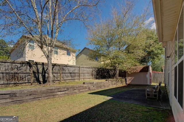 view of yard featuring a storage unit and a patio