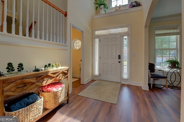 entryway featuring a high ceiling, crown molding, and dark hardwood / wood-style flooring