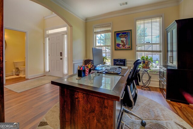 home office with crown molding, light hardwood / wood-style flooring, and a wealth of natural light