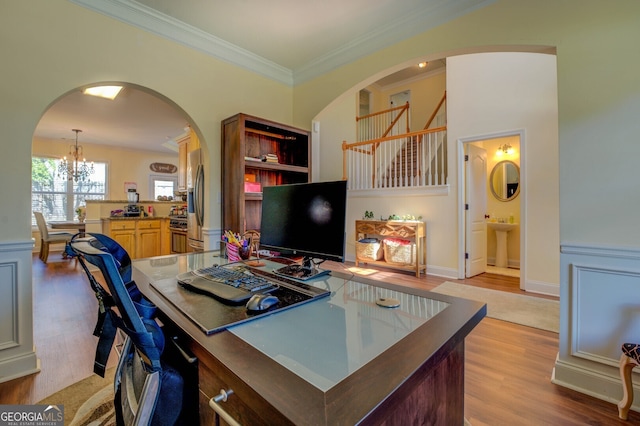 office area with light wood-type flooring, crown molding, sink, and a notable chandelier