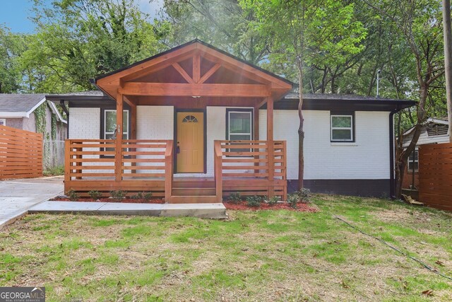 view of front facade featuring covered porch and a front yard