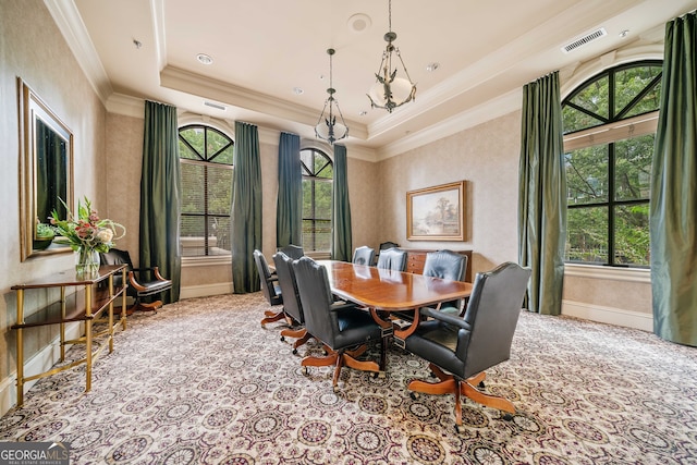 carpeted dining space featuring a raised ceiling, crown molding, and a wealth of natural light