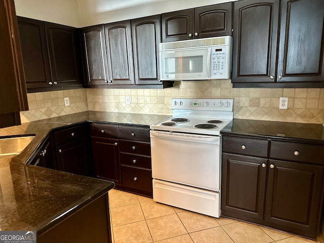 kitchen with sink, light tile patterned floors, white appliances, dark brown cabinets, and tasteful backsplash