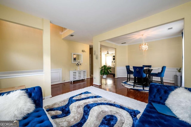 living room featuring ornamental molding, a notable chandelier, and hardwood / wood-style flooring