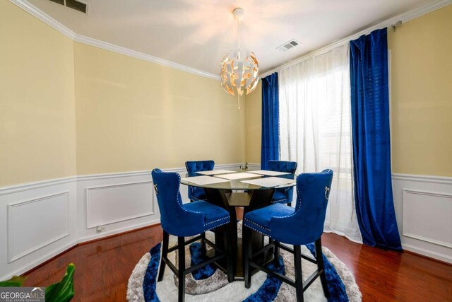 dining space featuring an inviting chandelier, dark wood-type flooring, and ornamental molding