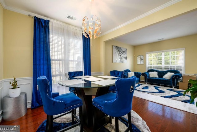 dining room with a notable chandelier, dark hardwood / wood-style floors, and crown molding