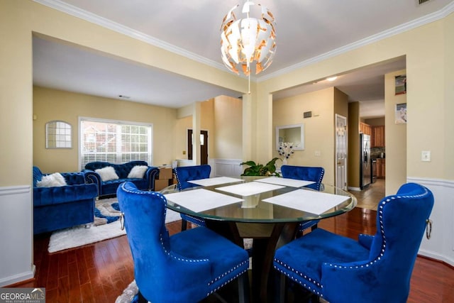 dining area with an inviting chandelier, dark hardwood / wood-style floors, and ornamental molding