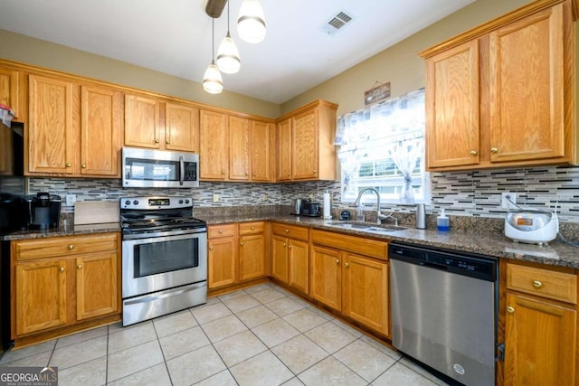 kitchen featuring light tile patterned flooring, stainless steel appliances, backsplash, and sink