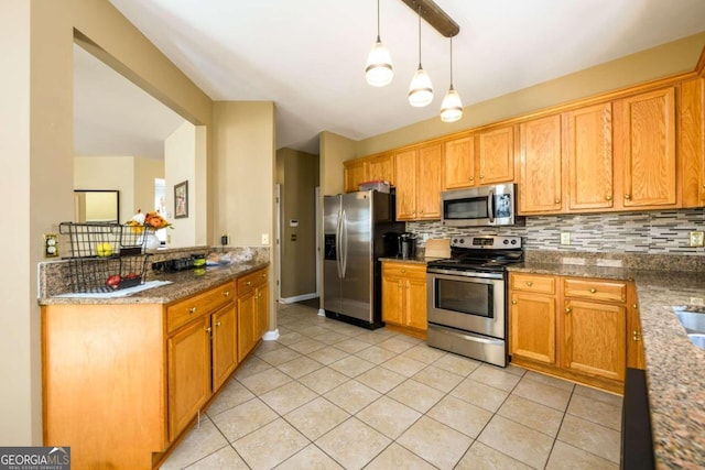 kitchen featuring pendant lighting, light tile patterned flooring, stainless steel appliances, backsplash, and dark stone countertops