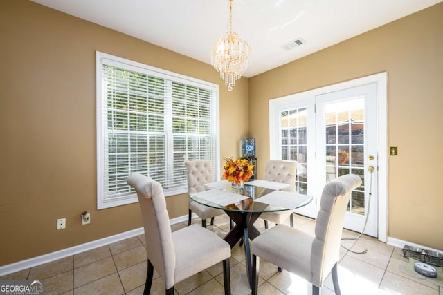 tiled dining room featuring a chandelier