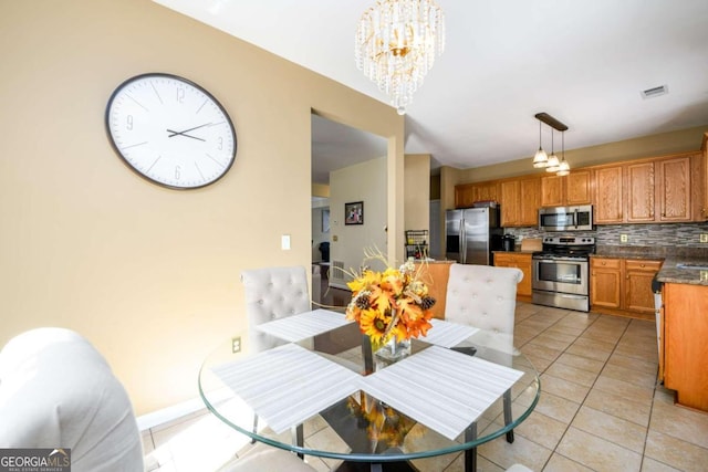 tiled dining room featuring a chandelier