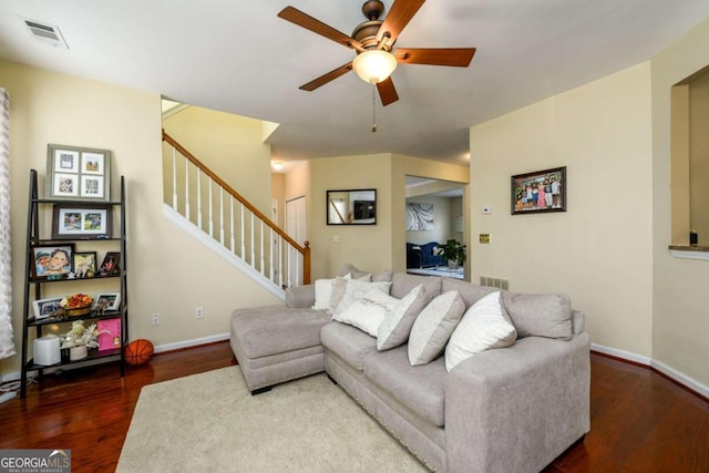 living room with ceiling fan and dark wood-type flooring