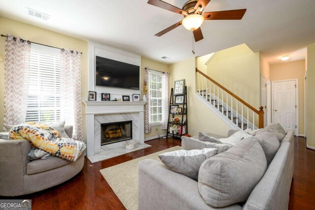 living room with a wealth of natural light, a premium fireplace, and dark hardwood / wood-style flooring