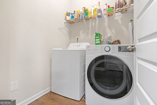 clothes washing area featuring washing machine and clothes dryer and hardwood / wood-style floors