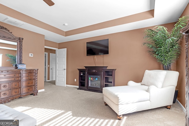 living room with light carpet and a tray ceiling