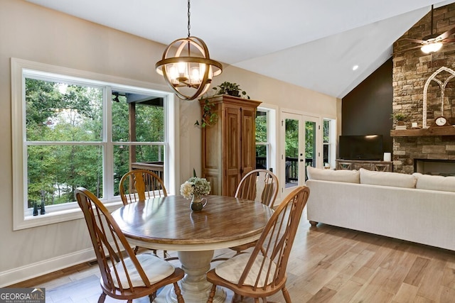 dining room featuring light wood-type flooring, vaulted ceiling, and a healthy amount of sunlight