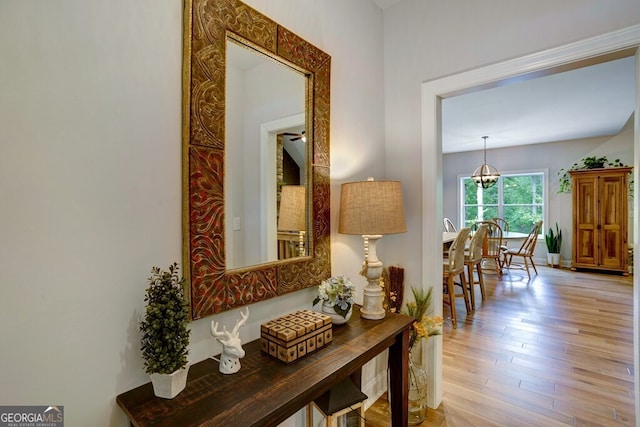 hallway featuring light hardwood / wood-style flooring and a chandelier