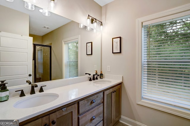 bathroom with a shower with door, vanity, and plenty of natural light