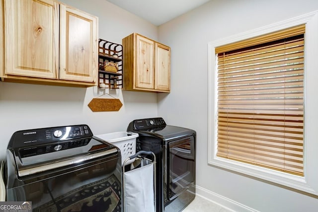 washroom with cabinets and washer and dryer