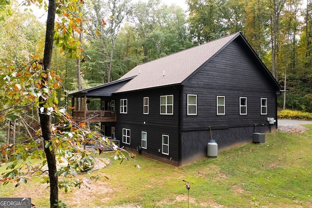 view of property exterior with a lawn, cooling unit, and a deck