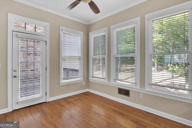 unfurnished sunroom featuring ceiling fan