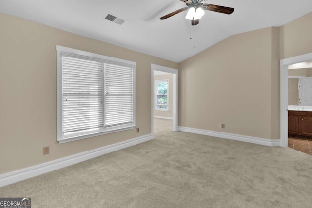 carpeted spare room featuring lofted ceiling and ceiling fan