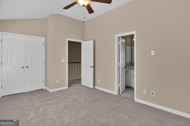 unfurnished bedroom featuring ceiling fan, a closet, ensuite bath, and light carpet