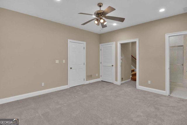 unfurnished bedroom with ceiling fan, connected bathroom, and light carpet