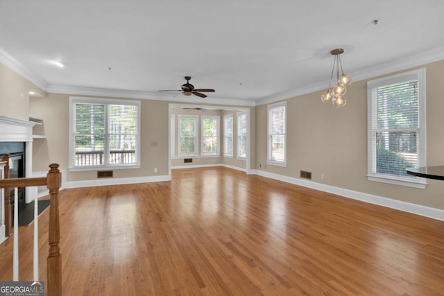 unfurnished living room with ceiling fan with notable chandelier, light hardwood / wood-style floors, and crown molding