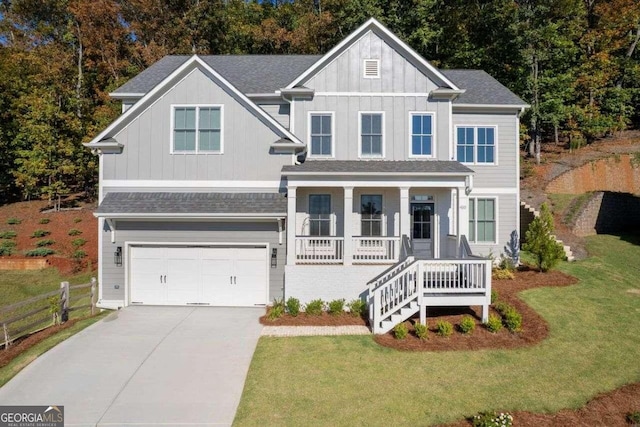 view of front of home with covered porch, a front yard, and a garage