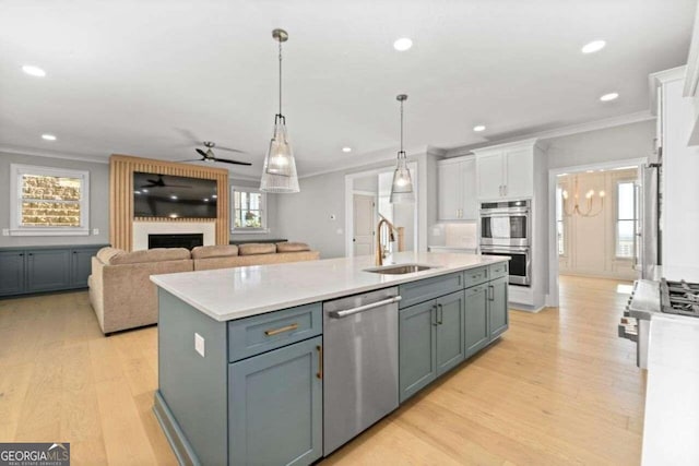 kitchen featuring an island with sink, light hardwood / wood-style floors, stainless steel appliances, and a wealth of natural light